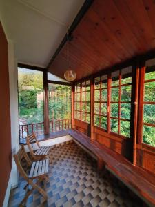 un porche cubierto con 2 sillas y ventanas en ApartVilla Trieste, en Trieste