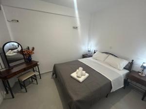 a bedroom with a bed and a table and a mirror at Kalofas Apartments Amaryllis in Ofrínion