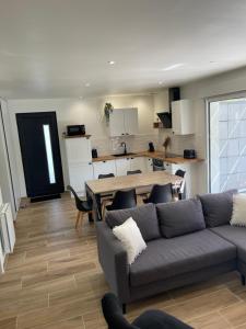 a living room with a couch and a table and a kitchen at Gîte la Chotinière in Mareuil-sur-Cher +6 photos
