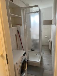 y baño pequeño con ducha y lavadora. en Monteur-Pension N2, 