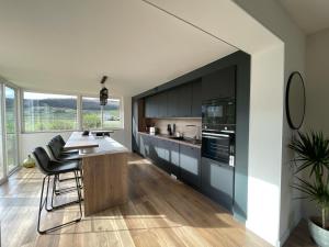 a kitchen with black cabinets and a table and chairs at La Maison Fonteny, Gevrey Chambertin in Gevrey-Chambertin
