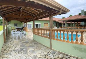 a patio with a wooden deck with a table and chairs at Chácara Nativa in Vargem
