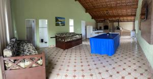 Habitación grande con mesa azul y cocina. en Chácara Nativa en Vargem