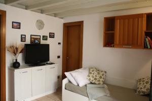 a living room with a tv and a couch at Sweet House a Veronetta - A pochi metri dal Centro in Verona