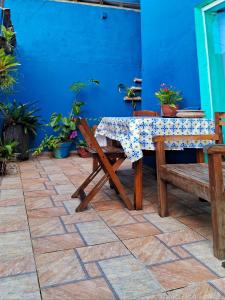 a table and a bench and a blue wall at Pousada Caminho do Mar in Paraty