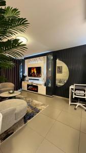 a living room with a couch and a tv at D&DLuxury Rivonia Apartments with inverter in Johannesburg