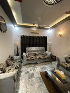 a living room with couches and a table at Travellers Home 2BR Portion Gulshan Iqbal blk 7 in Karachi