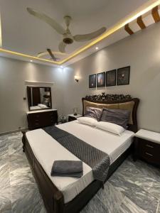 a bedroom with a large bed with a ceiling at Travellers Home 2BR Portion Gulshan Iqbal blk 7 in Karachi