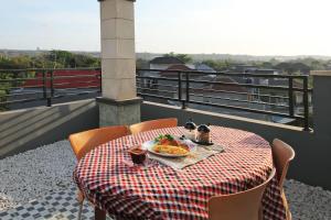 a table with a plate of food on a balcony at Ramantika Bali House in Jimbaran