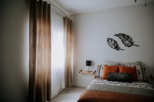 een slaapkamer met een bed met oranje kussens bij Casa Los Helechos in Aguascalientes