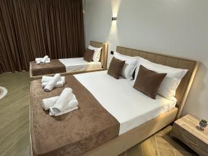 2 Betten in einem Hotelzimmer mit Handtüchern darauf in der Unterkunft Three Brothers in Shirokë