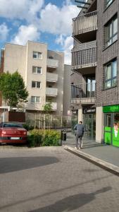 ワルシャワにあるOdkryta Warszawa! - prywatne mieszkanie, samodzielne zameldowanie, private studio balcony, free wifi, smart tv 55", parking, self check in - Warsaw Northの建物前の道を歩く男