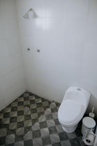 een badkamer met een wit toilet en een geruite vloer bij Casa Los Helechos in Aguascalientes