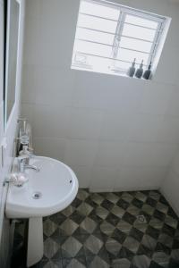 een witte wastafel in een badkamer met een raam bij Casa Los Helechos in Aguascalientes