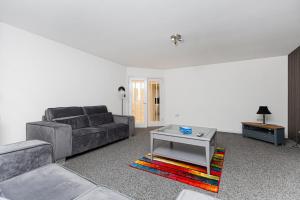uma sala de estar com um sofá e uma mesa em New Build 4 bed Det House in Yorkshire Nr Leeds em Batley