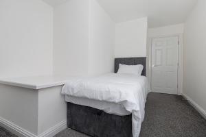 a white bedroom with a bed with a white blanket at New Build 4 bed Det House in Yorkshire Nr Leeds in Batley