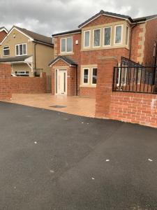 uma casa de tijolos com uma entrada em frente em New Build 4 bed Det House in Yorkshire Nr Leeds em Batley