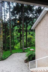 vistas a un patio con árboles y a un edificio en Pousada Recanto Vó Eni, en Gramado