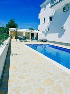 a swimming pool in front of a white building at Green paradise in Marina