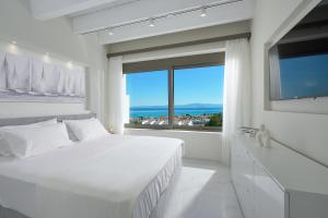 a white bedroom with a large bed and a large window at Villa Paradisio 2, Pool, Sea View in Hanioti +63 photos