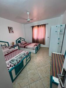 een kamer met 2 bedden en een raam bij Golden beach 2 Ras sedr Cozy chalet in Ras Sedr