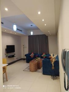 a living room with a blue couch and a tv at Sweet Living Homes Rental LLC in Dubai