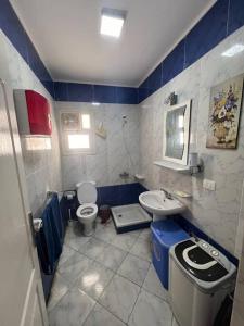 a blue and white bathroom with a toilet and a sink at Golden beach 2 Ras sedr Cozy chalet in Ras Sedr
