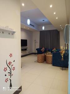 a living room with a blue couch and a tv at Sweet Living Homes Rental LLC in Dubai