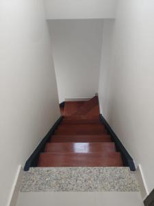 una rampa di scale in una camera con pavimenti in legno di Exclusiva Cobertura Duplex a Patos de Minas
