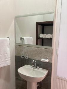La salle de bains est pourvue d'un lavabo et d'un miroir. dans l'établissement Excelente Loft Céntrico, à Zinapécuaro de Figueroa