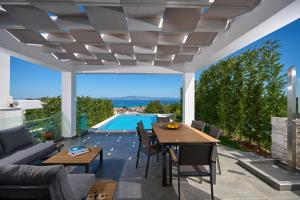 a patio with a table and chairs and a swimming pool at Villa Paradisio 2, Pool, Sea View in Hanioti