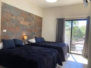 a hotel room with two beds and a window at Excelente Loft Céntrico in Zinapécuaro de Figueroa