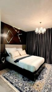 a bedroom with a large bed with a chandelier at D&DLuxury Rivonia Apartments with inverter in Johannesburg