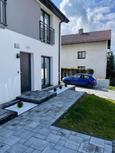 un coche azul estacionado frente a una casa blanca en Apartament Skłodowskiej, en Łańcut