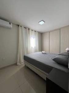 una camera con un grande letto e una finestra di Exclusiva Cobertura Duplex a Patos de Minas