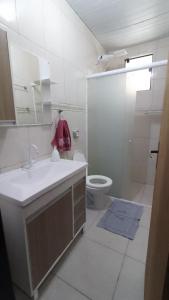 a white bathroom with a sink and a toilet at Fazendinha Mildau in Joinville