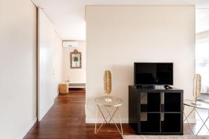 un salon avec une télévision et une chaise dans l'établissement Peaceful Zen Retreat, à Porto