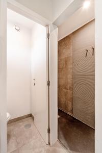 La salle de bains est pourvue de murs blancs et d'une porte coulissante. dans l'établissement Peaceful Zen Retreat, à Porto
