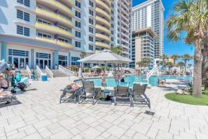a pool at a resort with people sitting in chairs at Luxurious Oceanfront Haven, Newly Remodeled 1BR with All-New Furnishings at the Wyndham Ocean Walk in Daytona Beach