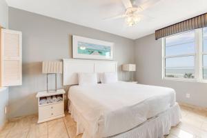 een witte slaapkamer met een groot bed en een raam bij Oceanfront Bliss 3BR Direct Ocean Front Retreat on the 4th Floor at The WyndhamOcean Walk Resort in Daytona Beach +41 foto's