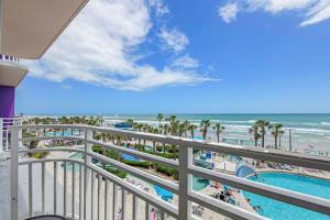 uitzicht op het strand vanaf het balkon van een resort bij Oceanfront Bliss 3BR Direct Ocean Front Retreat on the 4th Floor at The WyndhamOcean Walk Resort in Daytona Beach