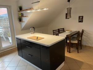 a kitchen with a counter and a dining table at Bambus, Jungle, Dachterrasse & bequem bis Zentrum in Radebeul