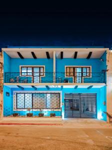a blue building with two garage doors at night at Casa Kuxul in Mérida