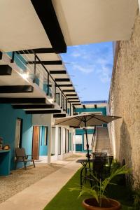 une terrasse avec une table et un parasol dans l'établissement Casa Kuxul, à Mérida