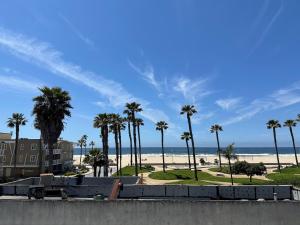 - une vue sur une plage avec des palmiers et un train dans l'établissement Grandview Inn, à Hermosa Beach