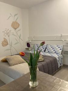 a vase with flowers on a table in a bedroom at La casetta in Cuneo