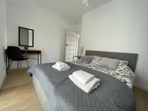 1 dormitorio con 1 cama con toallas en Apartament Skłodowskiej, en Łańcut