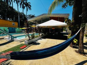 a blue hammock in front of a resort with a pool at LA CASONA SV in La Libertad