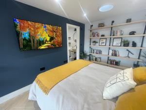 1 dormitorio con 1 cama con una pintura en la pared en The Nook @ Winchester. en Winchester