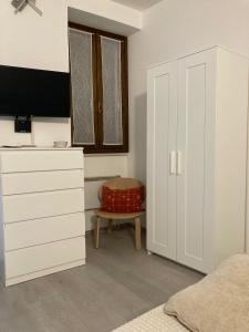 a bedroom with a bed and a dresser and a window at La casetta in Cuneo